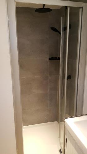 a shower with a glass door in a bathroom at Vakantiehuisje Lora in Middelkerke