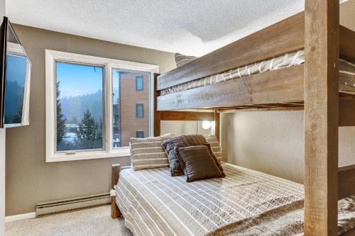 1 Schlafzimmer mit einem Etagenbett und 2 Fenstern in der Unterkunft Key Condo #2957 in Keystone