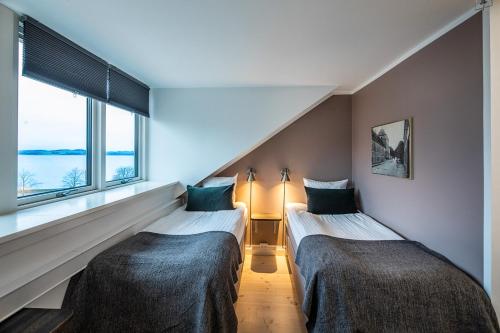 two beds in a room with a window at Hotel Sidesporet in Holbæk
