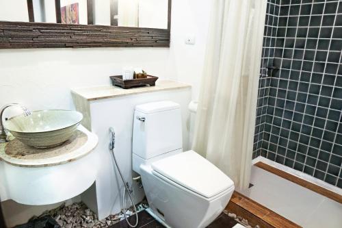 a bathroom with a toilet and a sink and a shower at Yantarasri Resort in Chiang Mai