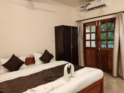 2 camas sentadas en una habitación con puerta en Dom's Inn en Calangute