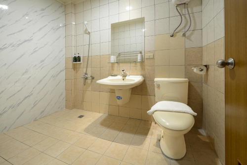 a bathroom with a toilet and a sink at Sun Moon Lake Loft Inn in Yuchi