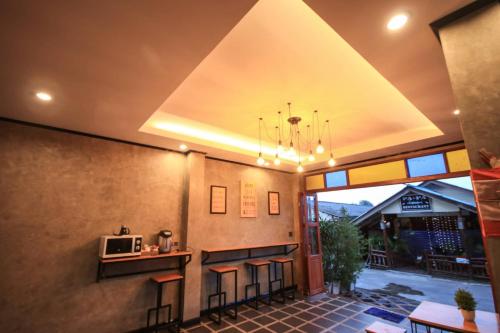 uma cozinha com um bar com bancos e um micro-ondas em Lanta Chaolay em Ko Lanta