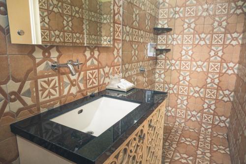 baño con lavabo y pared de azulejos en Ocean View Residence, en Jepara