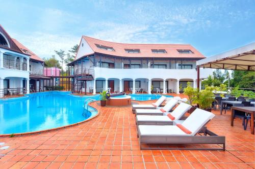 a resort with a swimming pool with lounge chairs and tables at The Pool Resort OKINAWA in Onna
