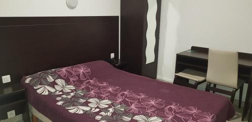 Le Petit-FossardにあるLE PETIT FOSSARD Montereau - Fontainebleauのベッドルーム(紫の毛布付きのベッド1台付)