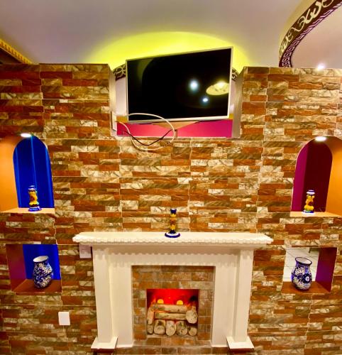 a fireplace with a tv on a brick wall at Hotel Boutique TEKALI INN in Cuetzalán del Progreso