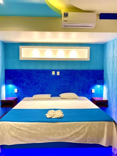 a bedroom with a white bed with blue walls at Hotel Boutique TEKALI INN in Cuetzalán del Progreso