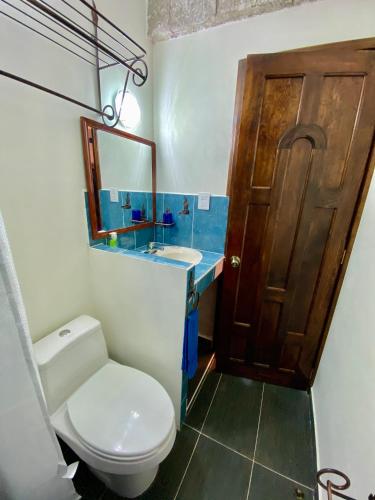 a bathroom with a toilet and a sink and a mirror at Hotel Boutique TEKALI INN in Cuetzalán del Progreso