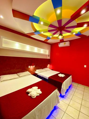 a room with two beds and a colorful ceiling at Hotel Boutique TEKALI INN in Cuetzalán del Progreso