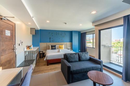 a hotel room with a bed and a couch at LawinTa Hotel Pattaya in Jomtien Beach