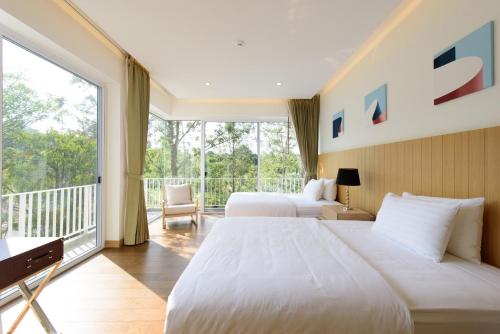 Una cama o camas en una habitación de The Gallery Khao Yai Hotel and Residence - SHA Plus
