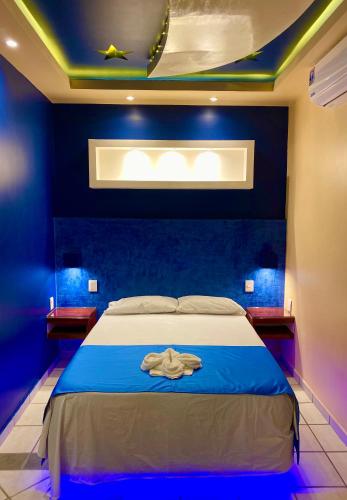 a bedroom with a bed with a blue wall at Hotel Boutique TEKALI INN in Cuetzalán del Progreso