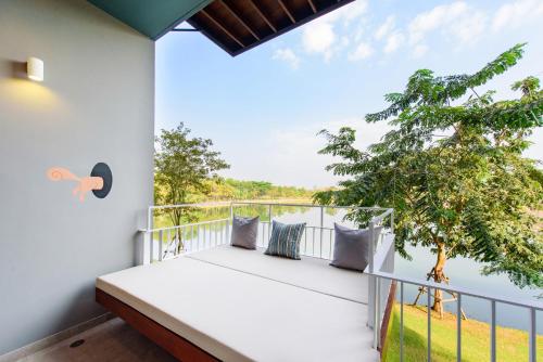 a balcony with a bed and a view of the water at The Gallery Khao Yai Hotel and Residence - SHA Plus in Khao Yai