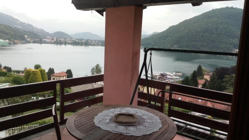 a table on a balcony with a view of a lake at Villa Panoramica in Lavena Ponte Tresa