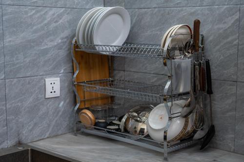 a shelf with plates and utensils on a wall at Sala Kanseng Home in Siem Reap