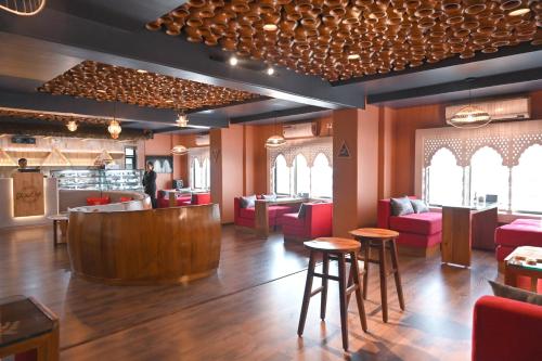 um restaurante com cadeiras vermelhas e um bar em The Classic Hotel em Imphal