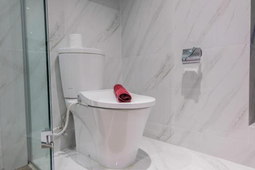 ein rotes Handtuch auf einem WC im Bad in der Unterkunft Fully Furnished 1BR at Branz BSD City Apartment By Travelio in Samporo