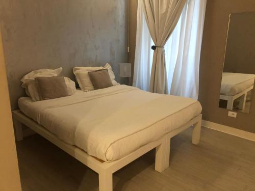 um quarto com uma grande cama branca e uma janela em House 5 em Trieste