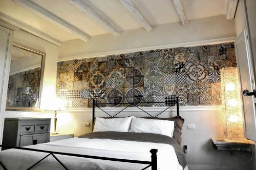 um quarto com uma cama e uma parede coberta de placas em Anime a Sud - Casa Kimiyà em Modica