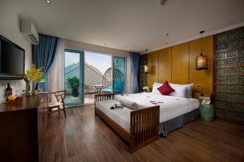 Habitación de hotel con cama grande, mesa y escritorio. en Hanoi Media Hotel & Spa, en Hanói