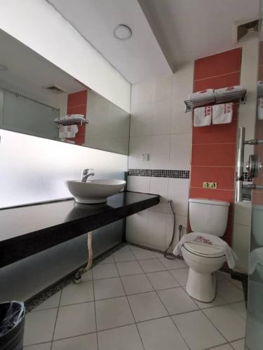 a bathroom with a toilet and a sink at Prince Hotel in Tawau