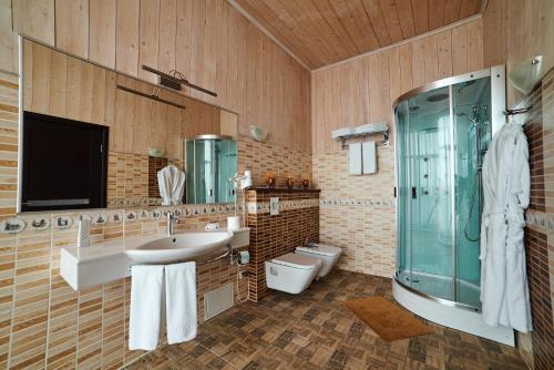 a bathroom with a sink and a shower and a toilet at Отель Арт-Ульяновск Левый берег in Ulyanovsk