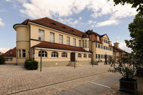 a large tan building with a red roof at Landschloss Korntal in Korntal-Münchingen