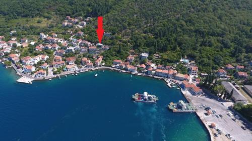 a red arrow pointing to a small town in a lake at Apartments Eftimov in Tivat
