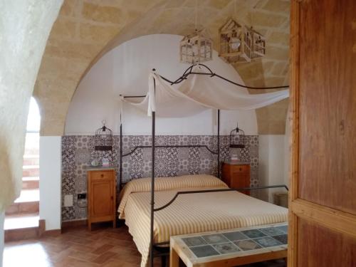 een slaapkamer met een hemelbed in een kamer bij Masseria Urbana in Crispiano