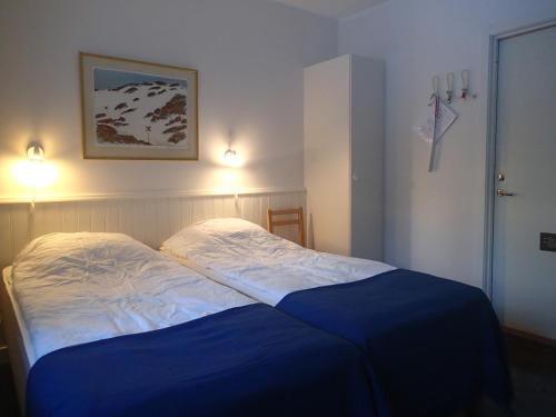 a bedroom with a bed with a blue blanket at Åreguiderna - Bubblans lägenheter Åre Torg in Åre