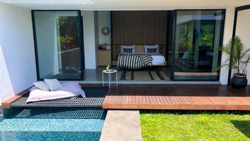 a patio with a bed and a pool at Origin Ubud in Ubud