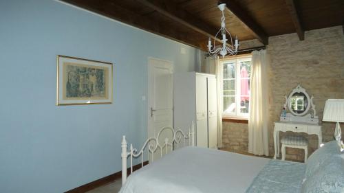 Lezay的住宿－Les Roses Trémières，卧室配有白色的床和窗户。