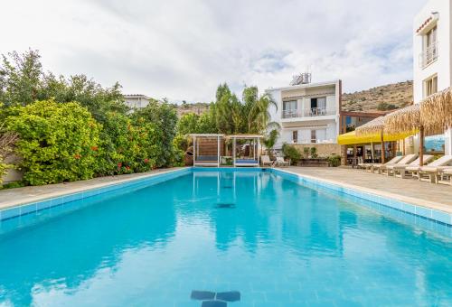 une grande piscine bleue en face d'un bâtiment dans l'établissement Antonis G. Hotel Apartments, à Oroklini
