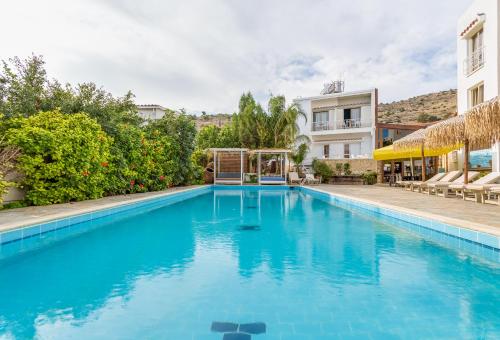 a large blue swimming pool in front of a building at Antonis G. Hotel Apartments in Oroklini