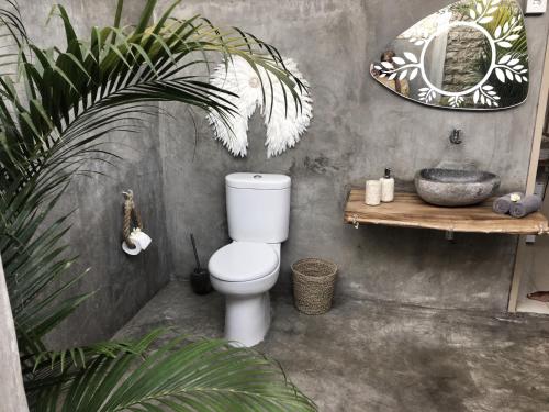 a bathroom with a toilet and a sink and a mirror at Incense Impossible Beach-Adults Only in Uluwatu