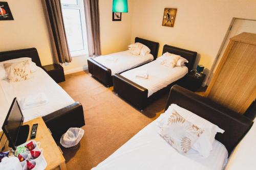 a hotel room with three beds and a table at The Kings Arms in Shap