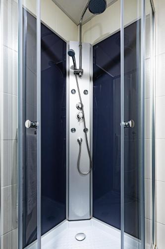 a shower with a glass door in a bathroom at Hotel-Restaurant Espace Squash 3000 in Mulhouse