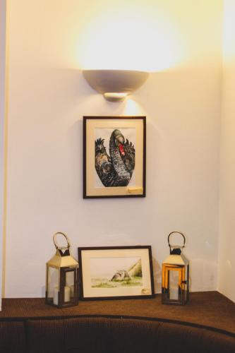 a table with two candles and pictures on a wall at The Kings Arms in Shap