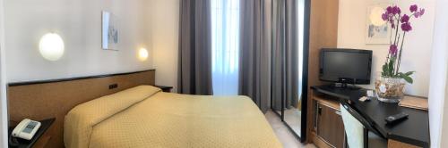 a hotel room with a couch and a television at Hotel Lamberti in Alassio