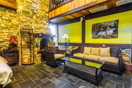 a living room with a couch and a stone wall at Provence Rose Lodge in Renai