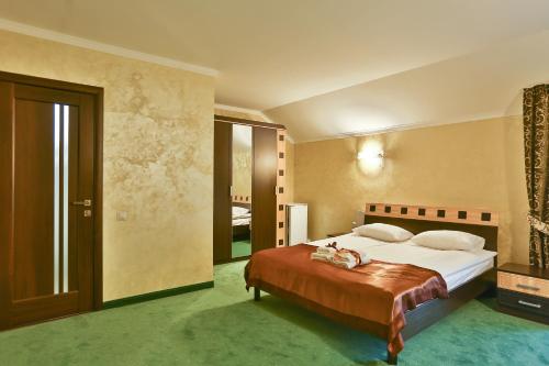 um quarto com uma cama grande num quarto em Роляда em Tysmenytsya