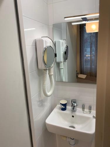 a bathroom with a sink and a mirror at Ménil Bon Temps in Paris