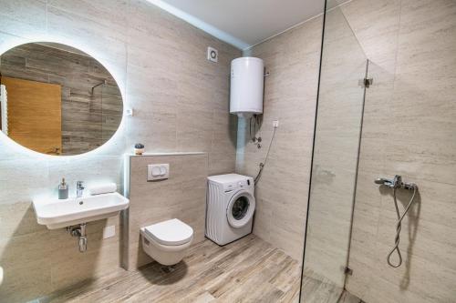 La salle de bains est pourvue de toilettes, d'un lavabo et d'une douche. dans l'établissement Arena BIG Luxury Apartments, à Novi Sad