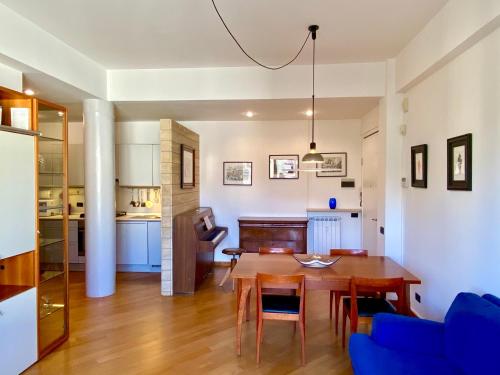 サン・テレンツォにあるMaison de Mauriのキッチン、リビングルーム(木製テーブル、青い椅子付)