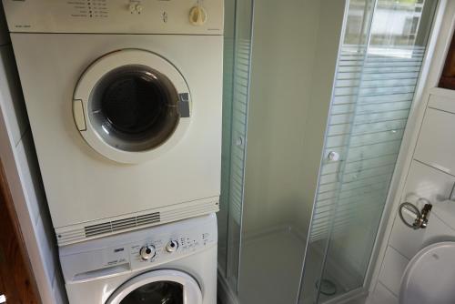 a washing machine and a washer and dryer in a bathroom at Chalet at a holiday park in Opmeer near Amsterdam in Opmeer