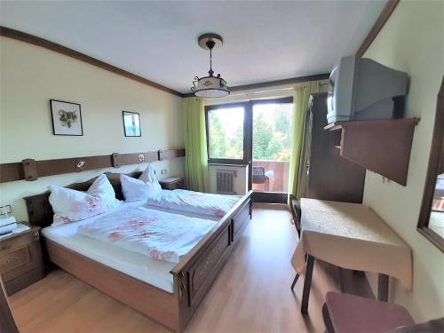 a bedroom with a large bed and a television at Birkenhof in Millstatt
