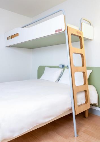 a bunk bed with a ladder in a room at ibis budget Caen Hérouville in Hérouville-Saint-Clair