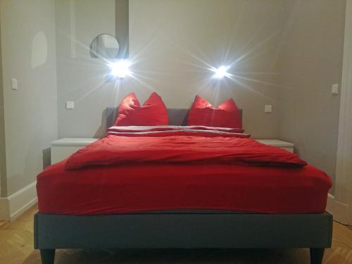 czerwone łóżko z 4 czerwonymi poduszkami w obiekcie Appartment Sonneck we Fryburgu Bryzgowijskim