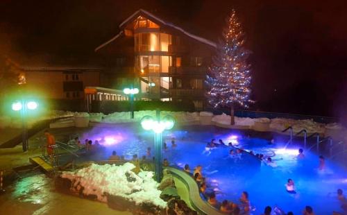 a christmas tree in a swimming pool at night at Hotel Viktoria-Leukerbad-Therme in Leukerbad
